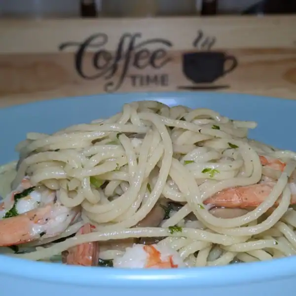 Pasta with Shrimps and Mushrooms in Olive Oil served on a blue plate.